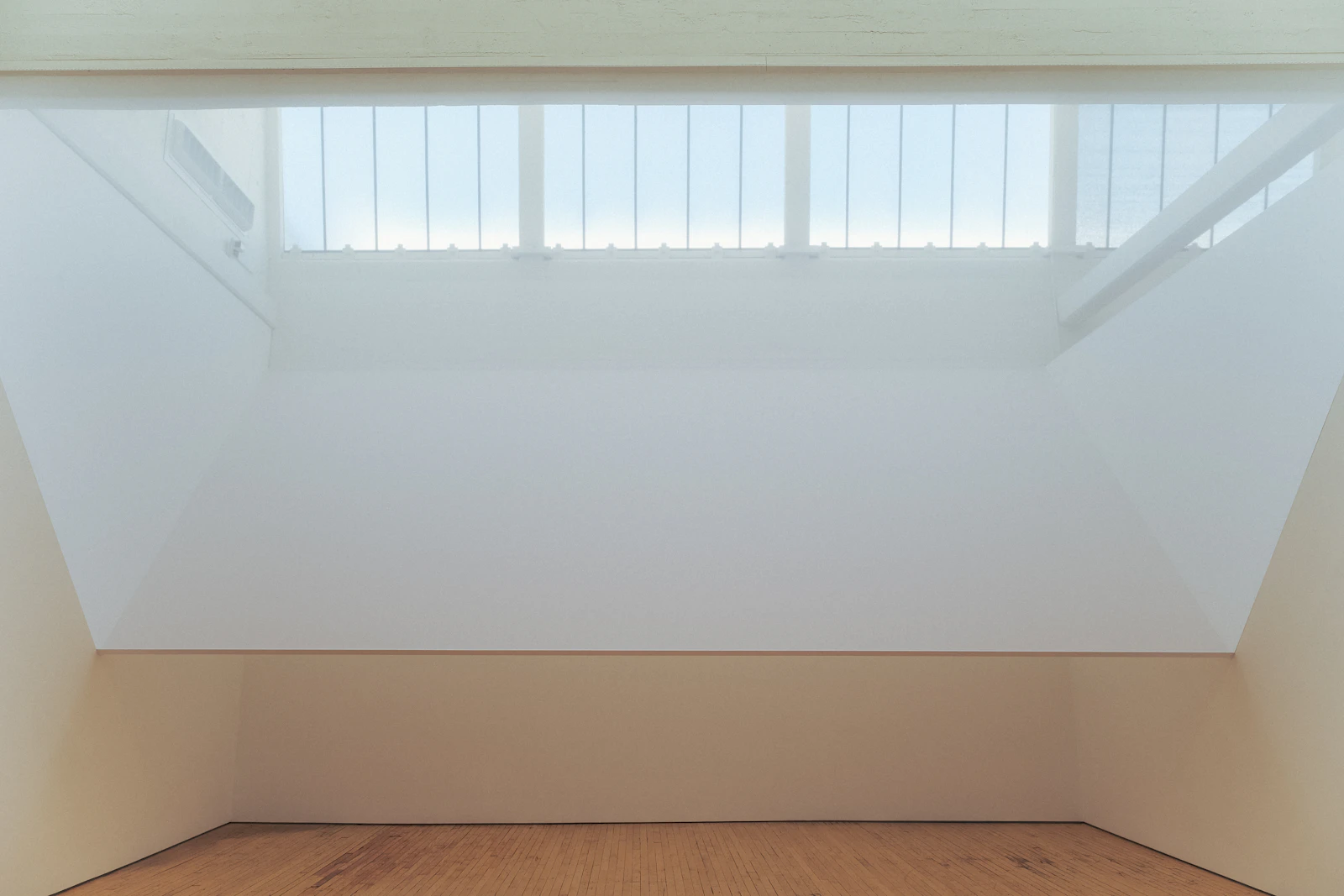 Sunlight fills a quiet studio with a wooden floor